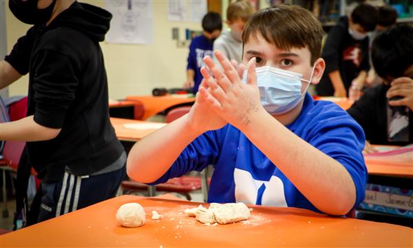 Boy rolls salt dough in his hands